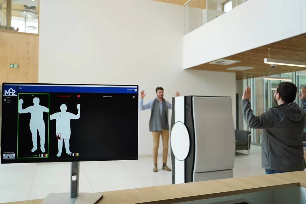 Vue écran de deux hommes se faisant vérifier par la MM-IMAGER